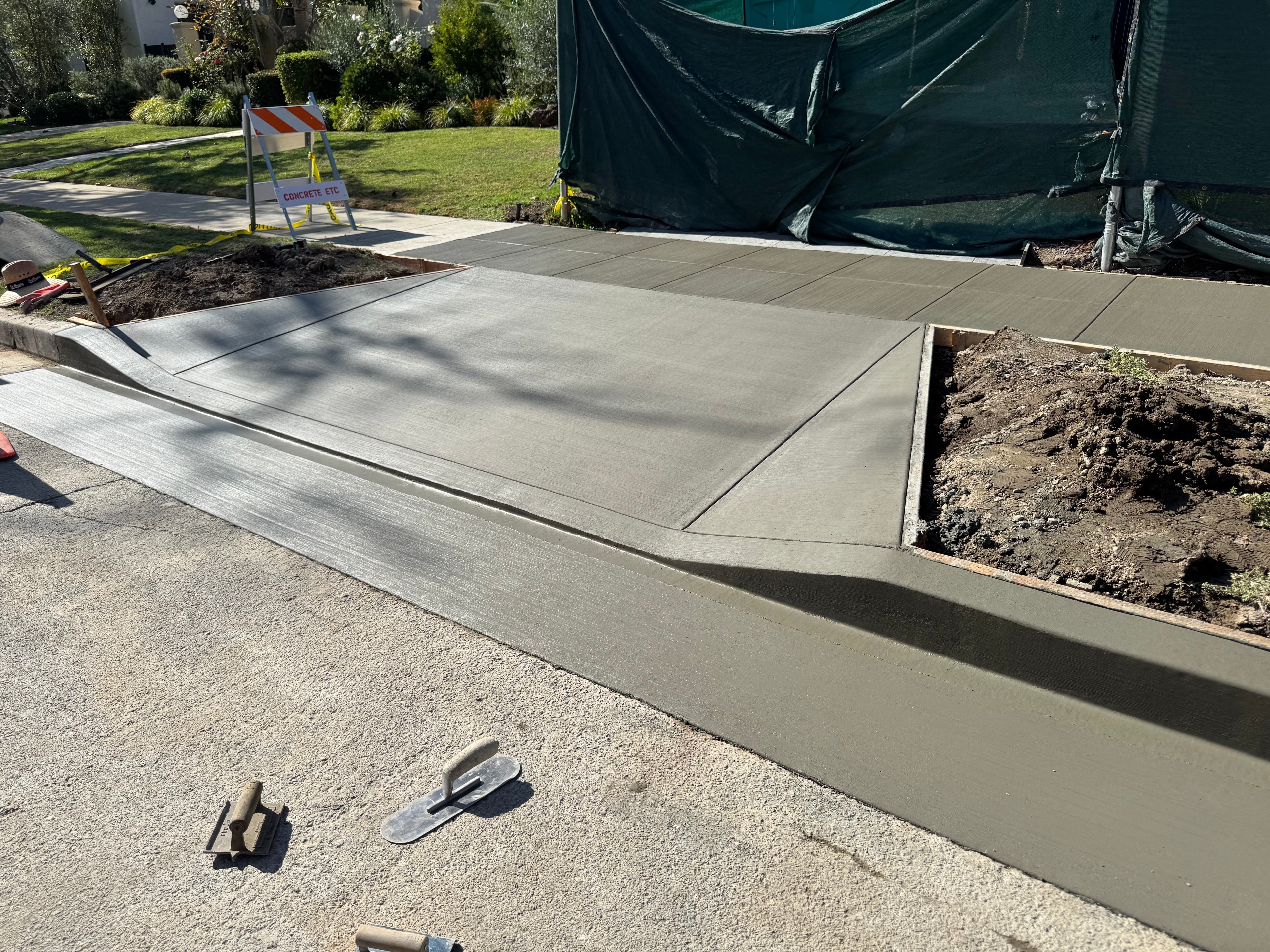 Freshly poured concrete driveway approach with Concrete Etc. signage — Los Angeles County