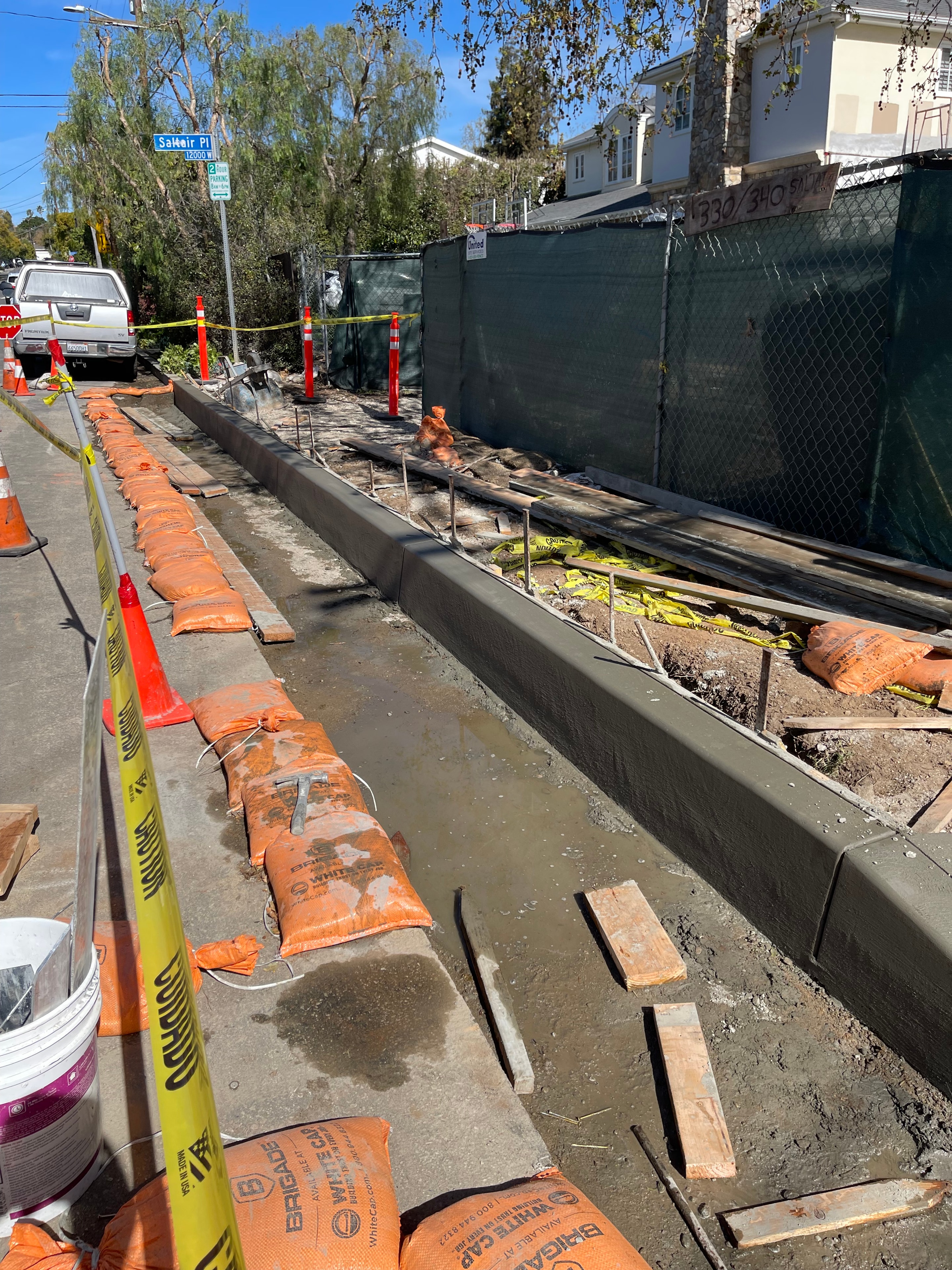 Public works curb and gutter pour with sandbags and caution tape in Los Angeles County by Concrete Etc., Inc.