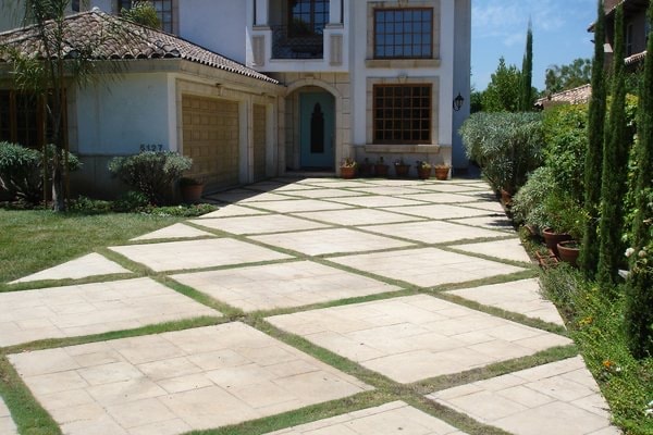 Stamped concrete driveway with grass joints and elegant home exterior Los Angeles County