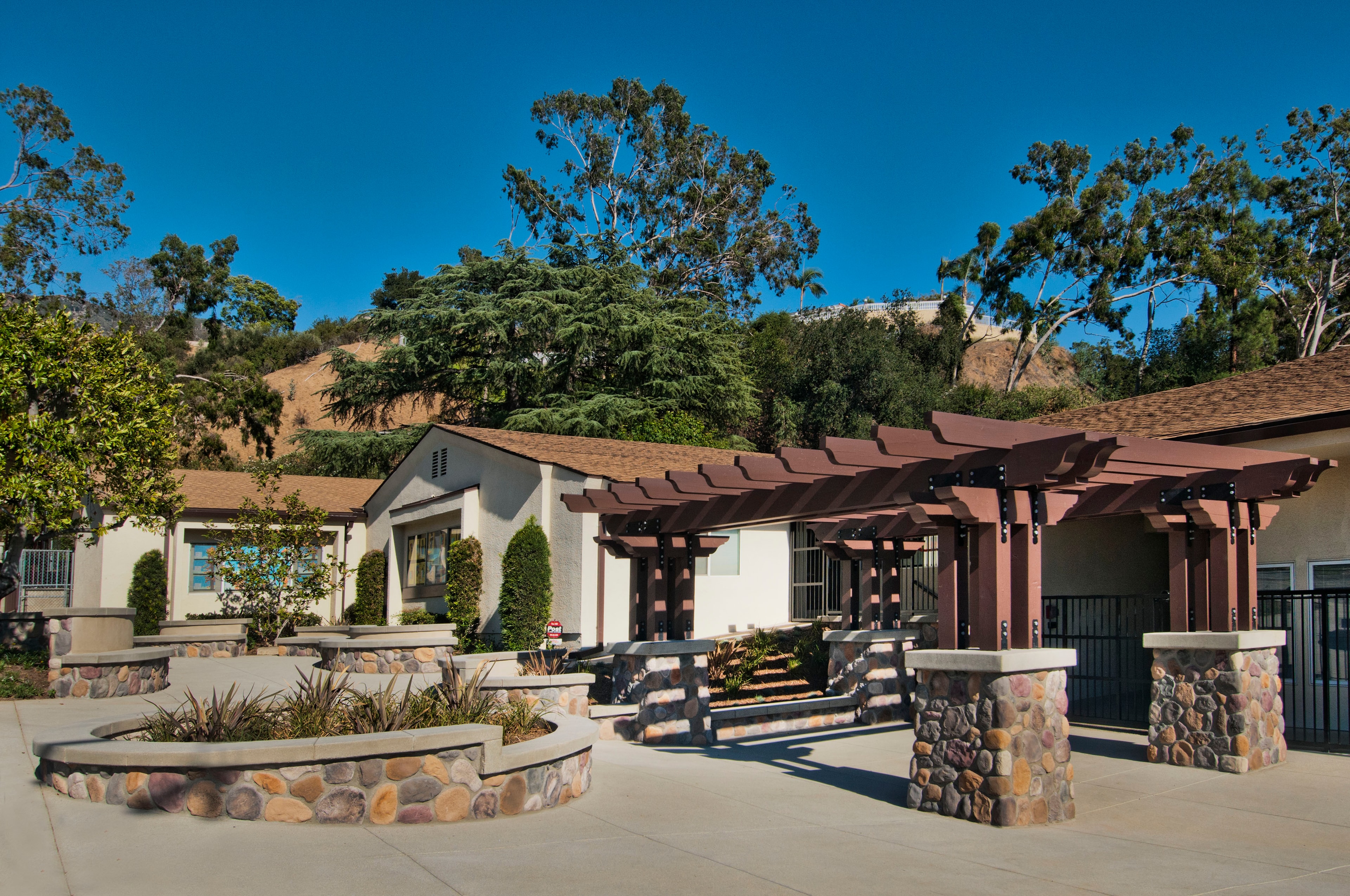 Completed courtyard with concrete flatwork, stone seating walls, and landscaping — Concrete Etc., Inc., Los Angeles County