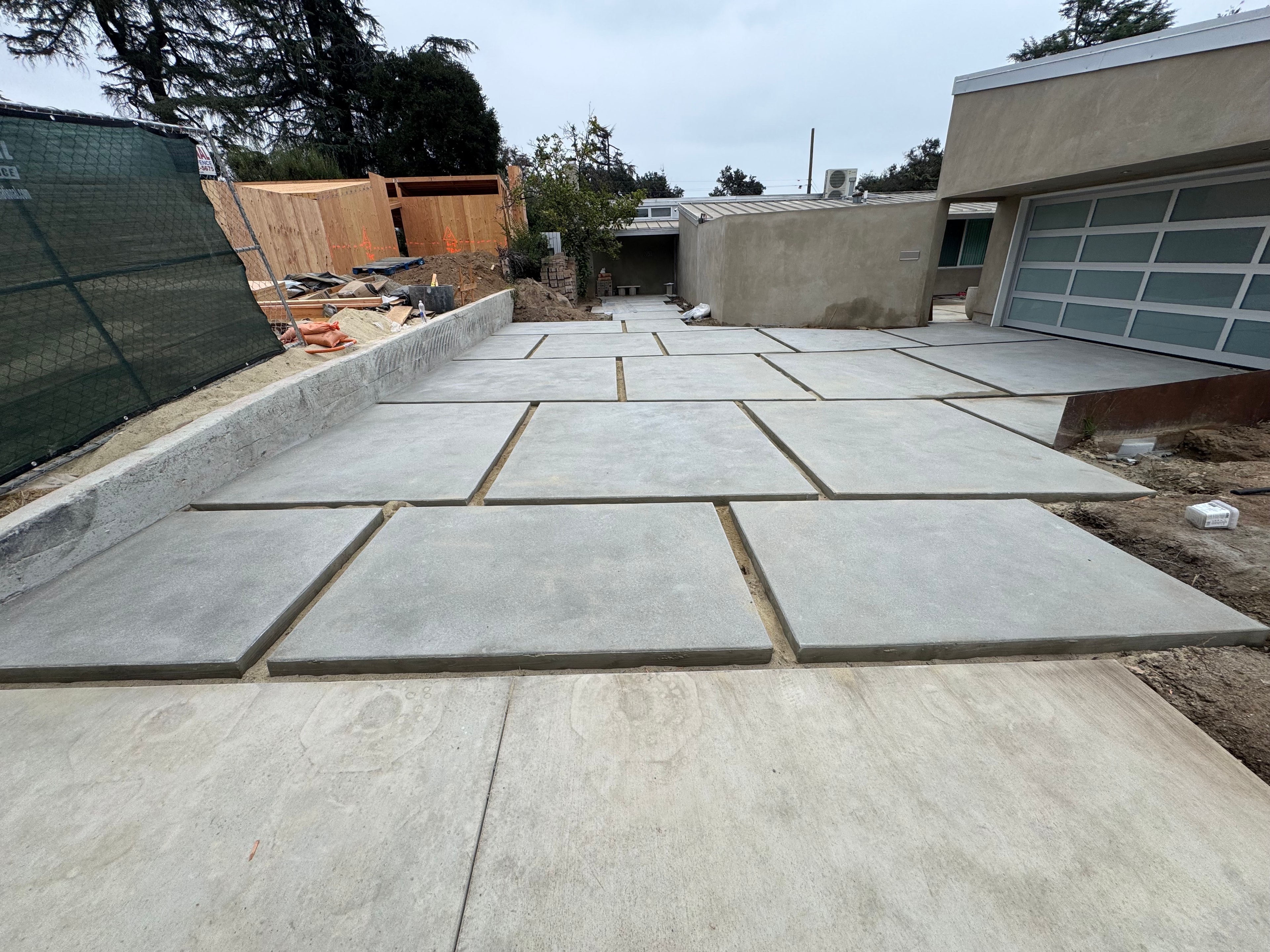 New concrete driveway with large slab panels under construction at residential home in Los Angeles County, CA - installed by Concrete Etc., Inc.